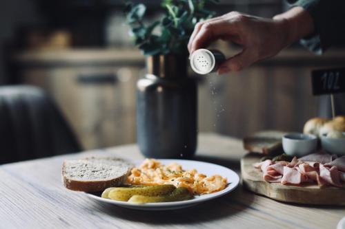 a person is sprinkling food onto a plate of food at Penzion U Kubesa - Adults only in Kroměříž