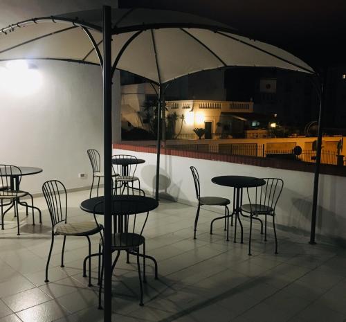 a group of tables and chairs under an umbrella at Villa Iavernaro in Pulsano