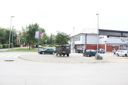 a parking lot with cars parked in front of a building at Apartman KEJ in Pirot