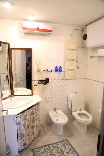 a bathroom with a sink and a toilet and a mirror at Little Paradise in Taormina