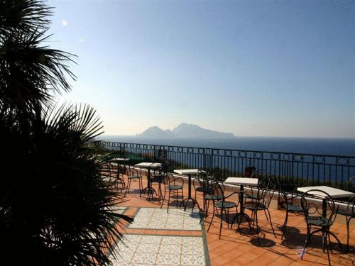 a group of tables and chairs on a patio overlooking the ocean at Hotel Villa Pina Antico Francischiello in Massa Lubrense