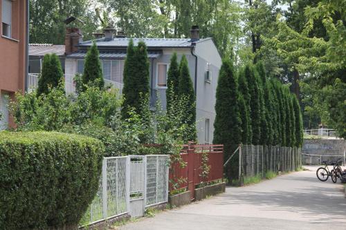 a white house with a fence and trees at Apartman KEJ in Pirot