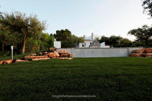 a yard with a retaining wall and a house at Residenza Lippolis in Castellana Grotte
