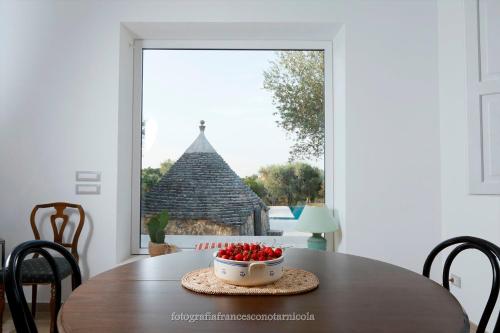 a bowl of strawberries sitting on a table in front of a window at Residenza Lippolis in Castellana Grotte