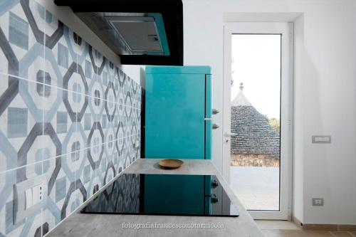 a blue cabinet in a kitchen with a window at Residenza Lippolis in Castellana Grotte