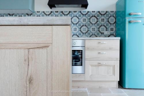 a kitchen with wooden cabinets and a blue refrigerator at Residenza Lippolis in Castellana Grotte