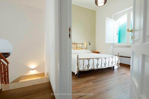 a white bedroom with a bed and a window at Residenza Lippolis in Castellana Grotte