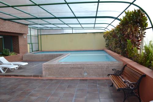 een zwembad in een patio met een bank bij Fontana: Location + Pool in Quito