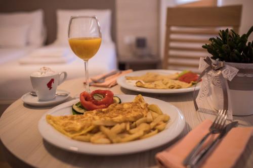a table with two plates of food and a glass of wine at Apartmani MG in Trebinje