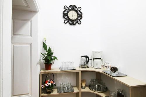 ein Regal mit Kaffeemaschine und eine Uhr an der Wand in der Unterkunft Anne's House in Sibiu