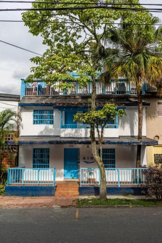a blue and white building with a tree in front of it at Air Guest House - con Desayuno & Jacuzzi Social in Medellín