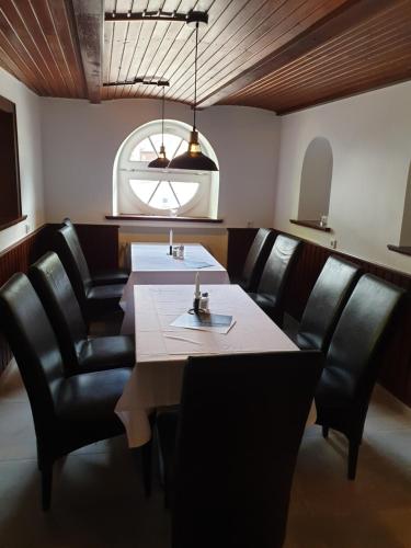 a dining room with a table and black leather chairs at El Capitan nähe Movie Park in Schermbeck