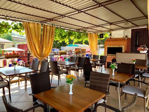 a patio with tables and chairs and a fireplace at Гостиница Эллада in Lazarevskoye