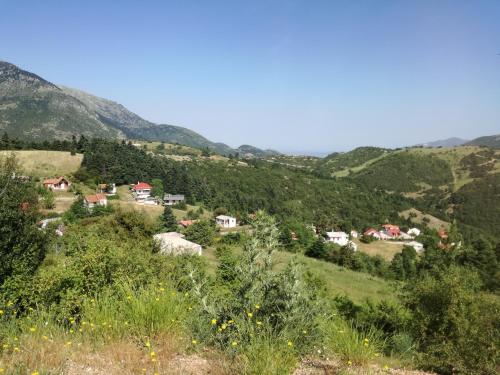 a small village on a hill with mountains in the background at The Magic Mountain in Tsapournia