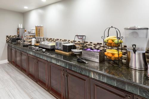a kitchen with a counter with fruit on it at La Quinta by Wyndham Visalia/Sequoia Gateway in Visalia