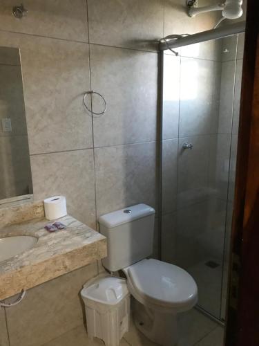 a bathroom with a toilet and a shower and a sink at HOTEL TURISMO MT in Chapada dos Guimarães