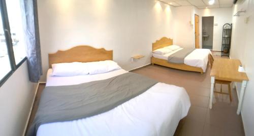 a small room with two beds and a desk at Grand Star Hotel in Melaka
