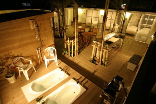 Habitación con vistas a un baño con bañera y una sala de estar. en Hanamuro Inn Aka Island, en Zamami