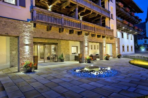 a courtyard with a fountain in front of a building at Das gemütliche Dorfhotel Kaltenhauser in Hollersbach im Pinzgau