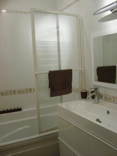 une salle de bain avec une baignoire, un lavabo et un miroir dans l'établissement Le moulin de la Castellerie, à Moon-sur-Elle