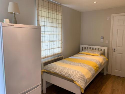 a small bedroom with a bed and a window at Studio in Stanmore