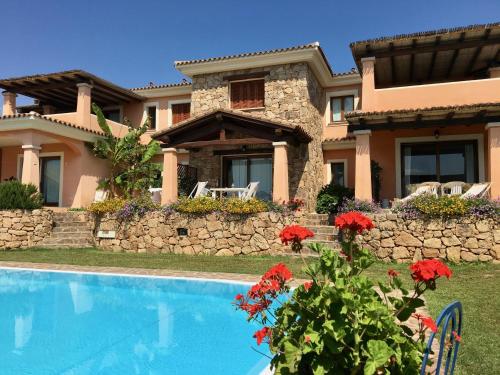 a villa with a swimming pool in front of a house at Le Dimore di Nettuno in Olbia