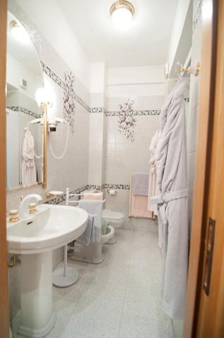 a white bathroom with a sink and a toilet at Hotel Ristorante Al Sorriso in Soriso