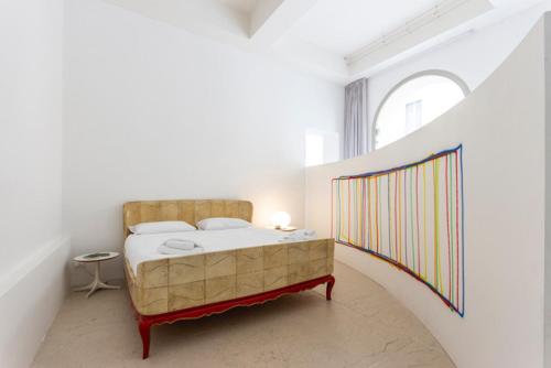 a bedroom with a bed in a white room at PALAZZO BECCAGUTTI CAVRIANI - Gallery Suite e Frescoes Suite in Mantova