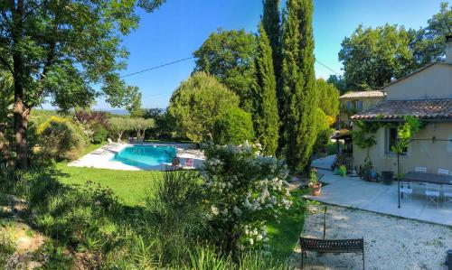 uma vista para um quintal com uma piscina e uma casa em Les Beaux Chenes em Pont-de-Barret