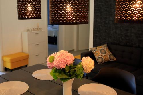 a living room with a table with a vase of flowers at MORE Podgora Luxury Design Apartment in Podgora