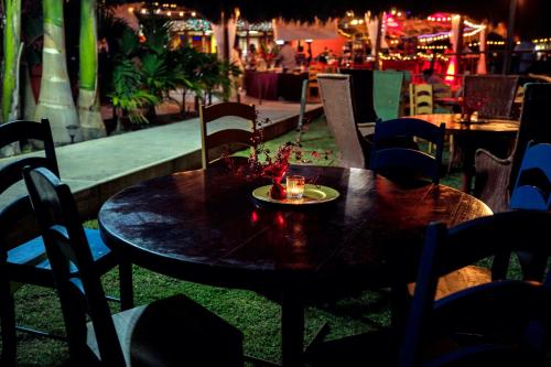 a table and chairs with a plate of food on it at Lamanai Hotel & Marina in Orange Walk