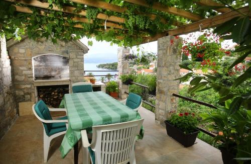 d'une terrasse avec une table, des chaises et une cheminée. dans l'établissement Apartments Neda - perfect location & free parking, à Splitska