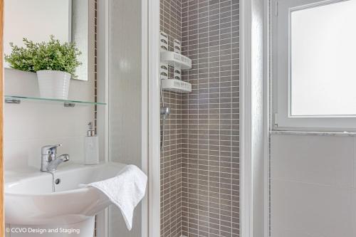 a bathroom with a sink and a shower at Apartamento Playa de Quenxe in Corcubión