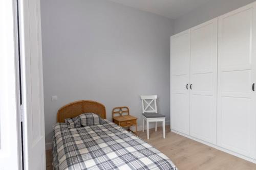 a bedroom with a bed and white cabinets at Apartamentos CASA CARRE 1893 in Santoña