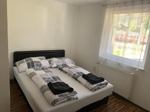 Una cama con dos almohadas y una ventana. en Nexis Apartment 10, en Radstadt