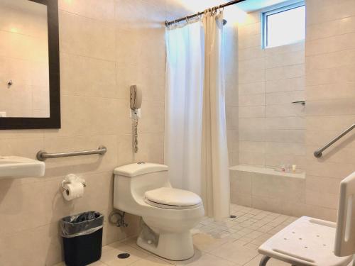 a bathroom with a toilet and a shower and a phone at Tryp by Wyndham Panama Centro in Panama City