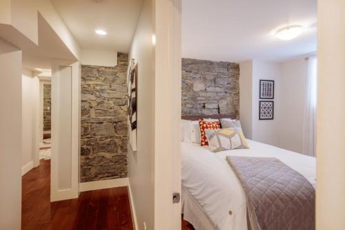 a bedroom with a bed and a stone wall at The Hillside House - Downtown Kingston in Kingston