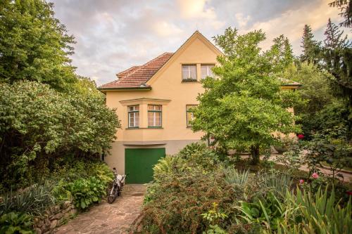 a yellow house with a green garage at Hübsches Privatzimmer mit Bad in Perchtoldsdorf