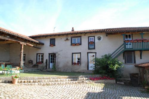 Una gran casa blanca con un patio enfrente. en Chez Jacotte et Elia, en Saint-Galmier