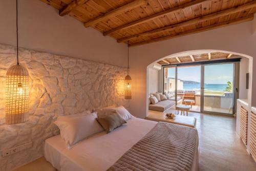 een slaapkamer met een bed en een stenen muur bij Meli Suites, Thassos in Skala Potamias