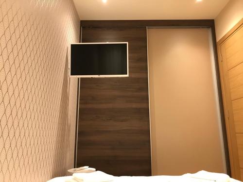 a bathroom with a tv on a wall with a mirror at Zlatibor apartman Chill out in Zlatibor