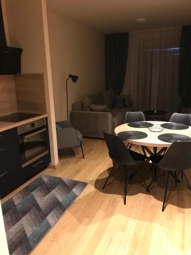 a kitchen and a living room with a table and chairs at Zlatibor apartman Chill out in Zlatibor