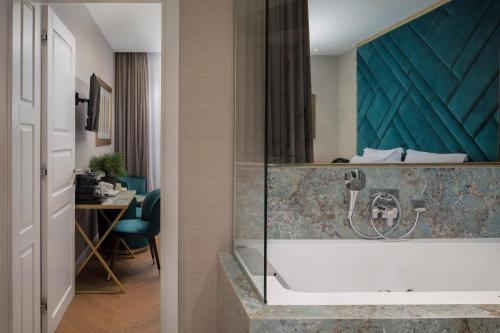 a bathroom with a bath tub and a bedroom at Five Elements Luxury Rooms in Split