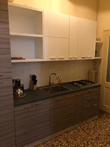 a kitchen with white cabinets and a sink at Appartamenti Paradiso in Venice