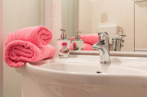 a bathroom with a sink with pink towels on it at Apartment Calista in Rabac