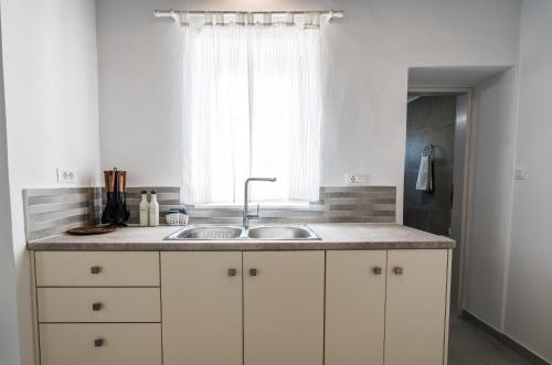 a kitchen with a sink and a window at Komis Mansion Exambela in Exámbela