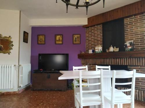 un soggiorno con tavolo e parete viola di Apartamento Turísticos Luar 3 a El Rasillo