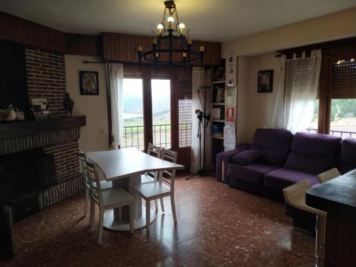 un soggiorno con tavolo e divano viola di Apartamento Turísticos Luar 3 a El Rasillo