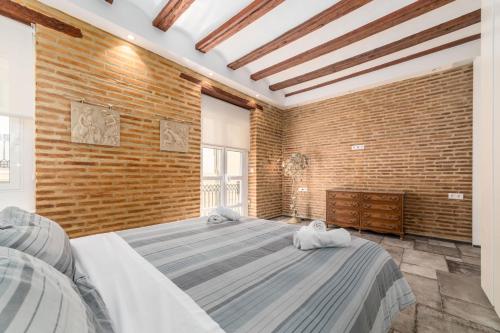 - une grande chambre avec un mur en briques et 2 lits dans l'établissement FLORIT FLATS - CENTER MODERN 1BR 2Bth TERRACE WI-FI AC, à Valence