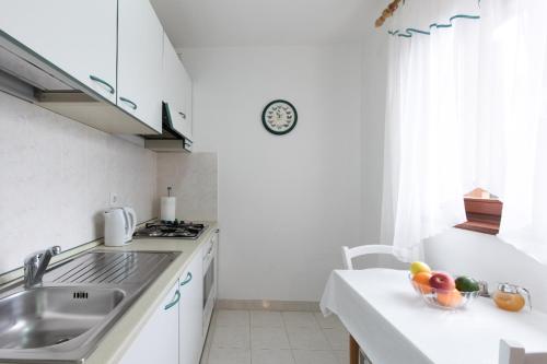 a kitchen with a sink and a counter with fruit in a bowl at Apartment Calista in Rabac